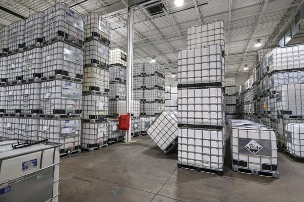 Stacks of 1000 litre IBC totes in an indoor warehouse