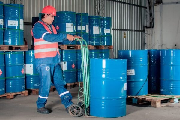 Worker moving blue drums in a warehouse